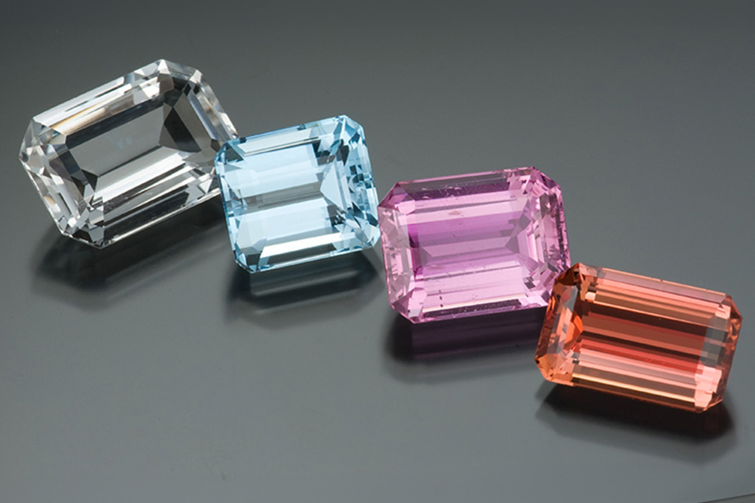 Topaz gemstones in four colours of colourless, light blue, pink and orange-red. 