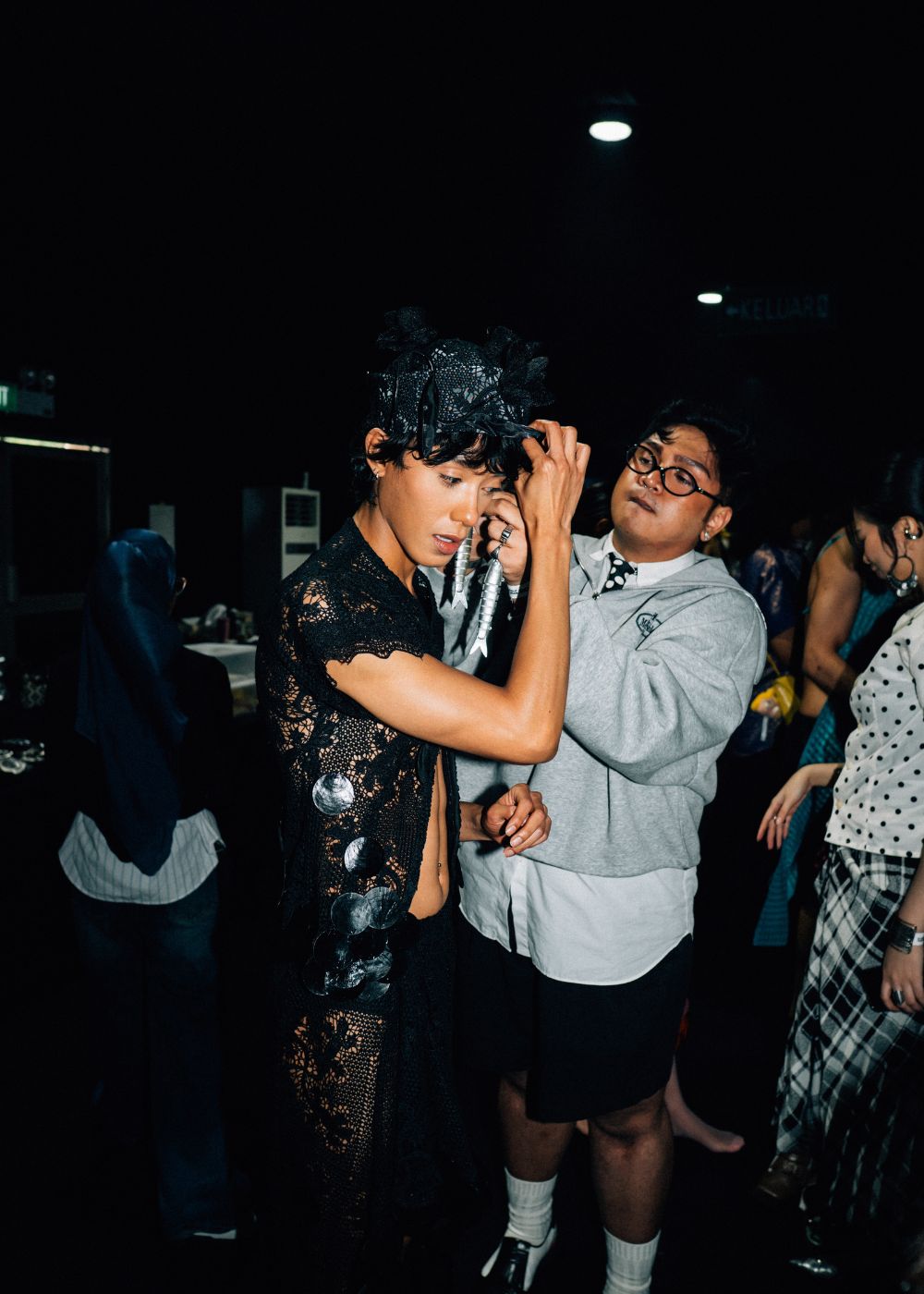 Uzair Shoid helping to put on earrings on model Hariz Izu.