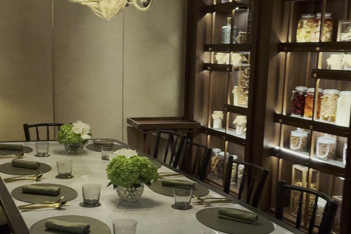 Spice Market restaurant at Anantara Siam Bangkok, shelves of spice jars above a marble dining table.